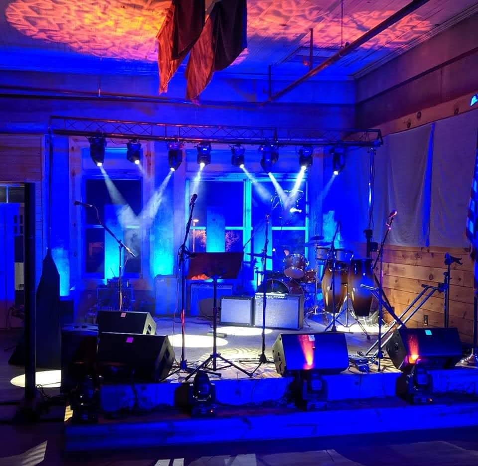 stage backlit in blue with spotlights shining up and down. 